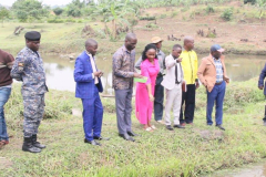 MINISTER-BYAMUKAMA-FEEDING-FINGERLINGS-OF-DR.-LUBEGA-AT-BUSEESA-DEMO.FARM-DURING-HIS-ASSESSMENT-TOUR-IN-KIBAALE-DISTRIC